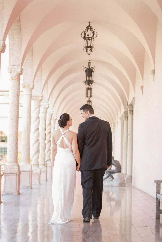 Bride and groom walking through the Ringling Museum archways in Sarasota