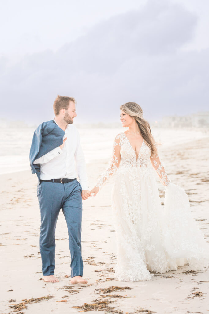 Bride and groom walking on St Pete Beach near The Don CeSar wedding venue
