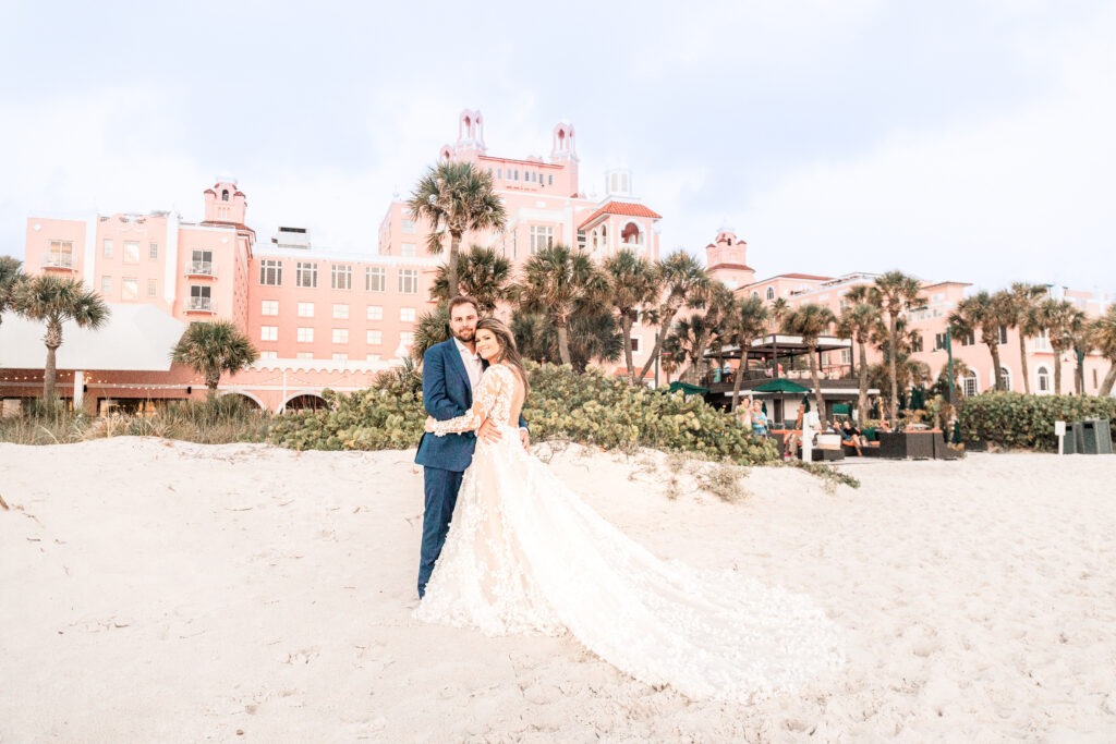 Bride and groom beach portrait with flowing wedding dress train at The Don CeSar