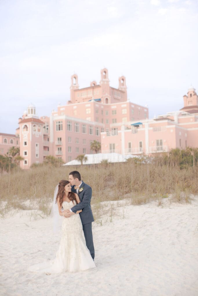 Bride and groom on St Pete Beach with The Don CeSar in background