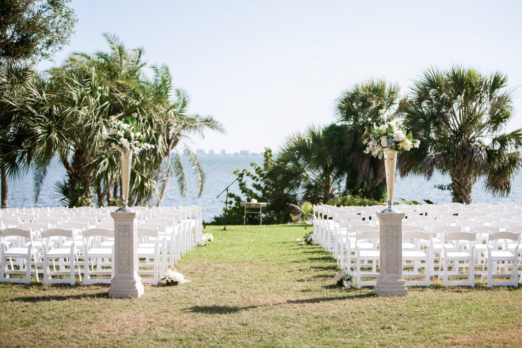 waterfront wedding ceremony aisle at Powel Crosley Estate Sarasota with palm trees and bay view