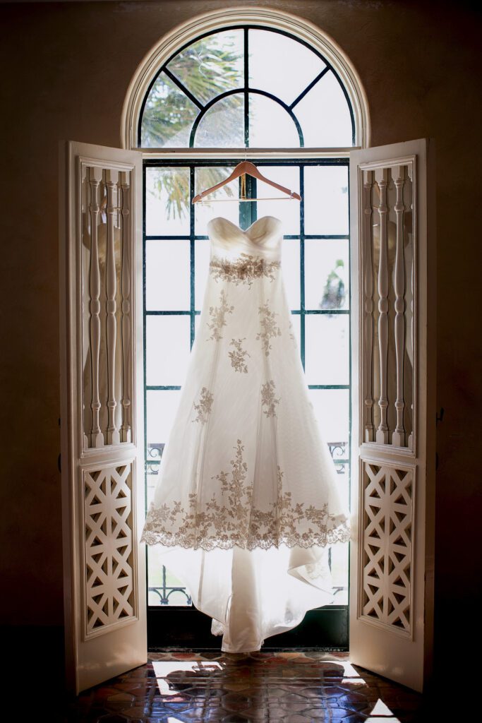 wedding dress hanging in arched doorway at Powel Crosley Estate Sarasota natural light