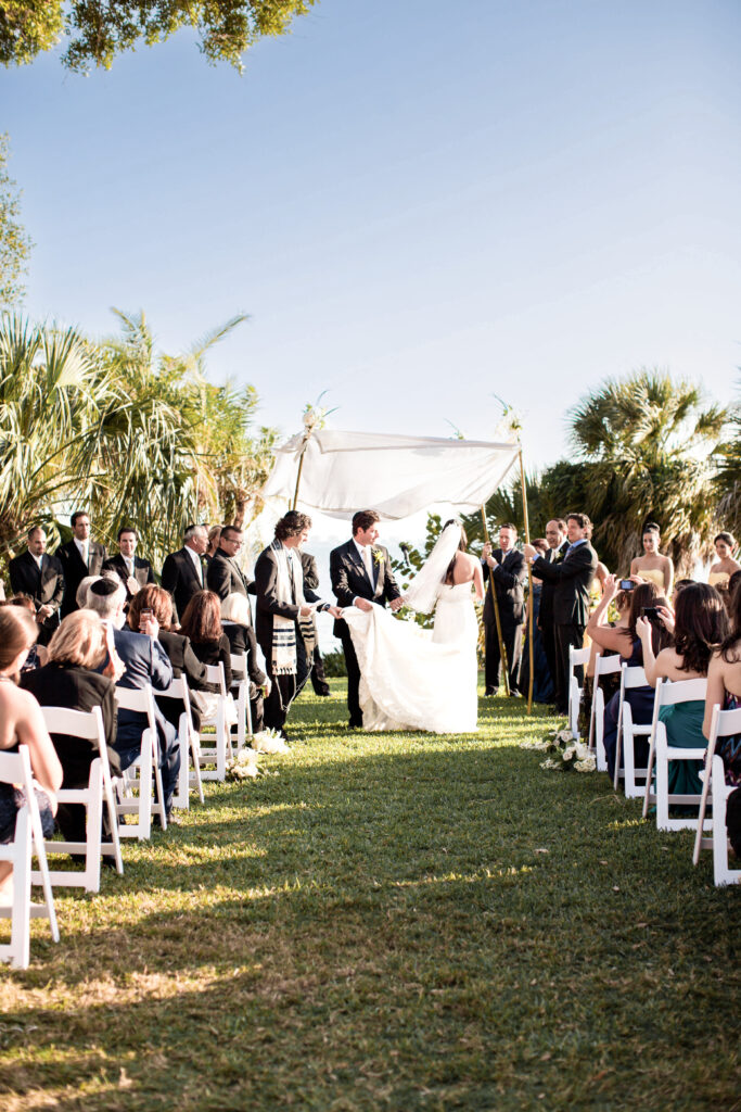 waterfront wedding ceremony at Powel Crosley Estate Sarasota with chuppah and bay view