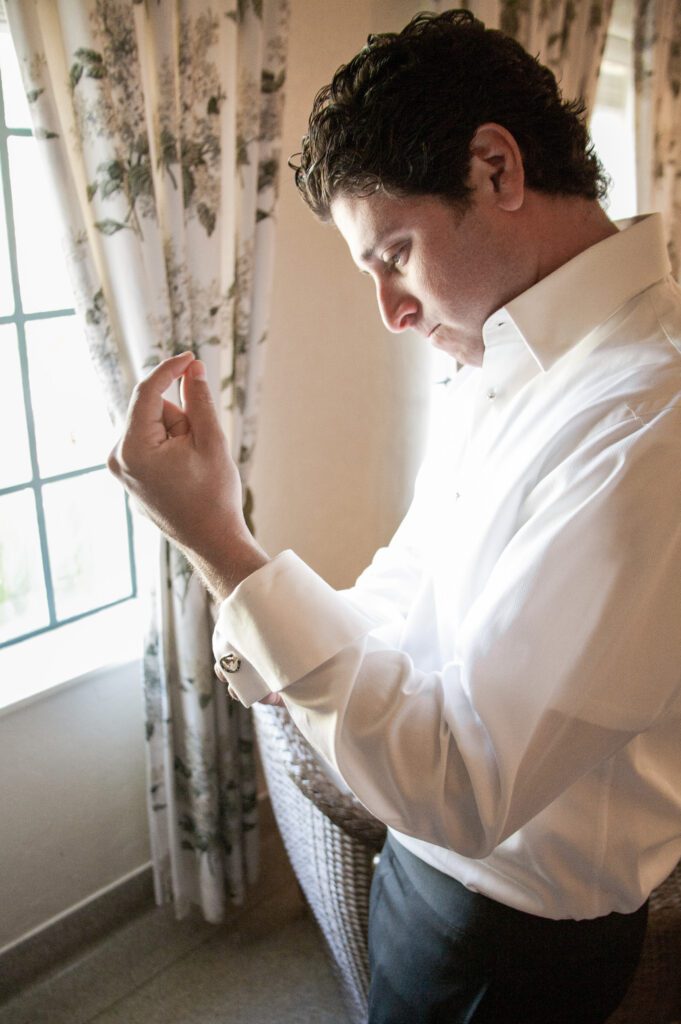 groom getting ready by window at Powel Crosley Estate Sarasota candid moment