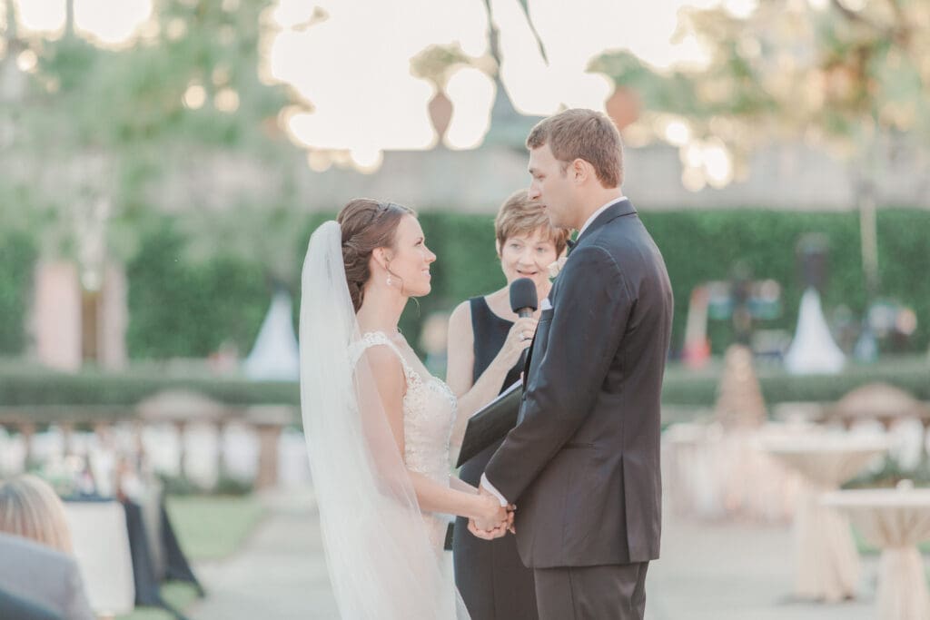 Bride and groom exchanging vows during an outdoor ceremony at The Ringling Museum courtyard in Sarasota Florida