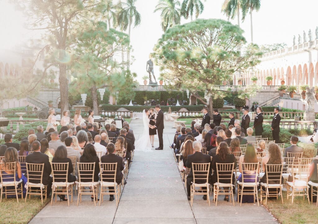 Bride and groom exchanging vows during an outdoor ceremony at The Ringling Museum courtyard in Sarasota Florida