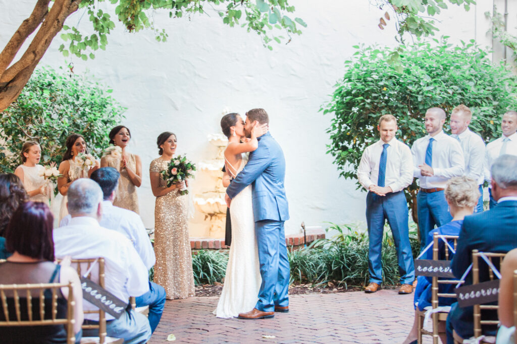 Bride and groom sharing first kiss at Museum of Fine Arts courtyard wedding