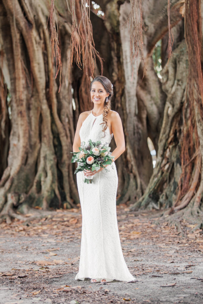Bride holding bouquet under banyan trees at St. Petersburg wedding venue