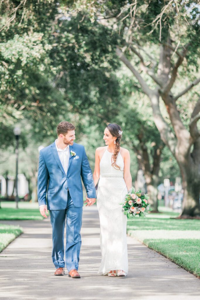 Bride and groom walking together under trees at Museum of Fine Arts St. Petersburg