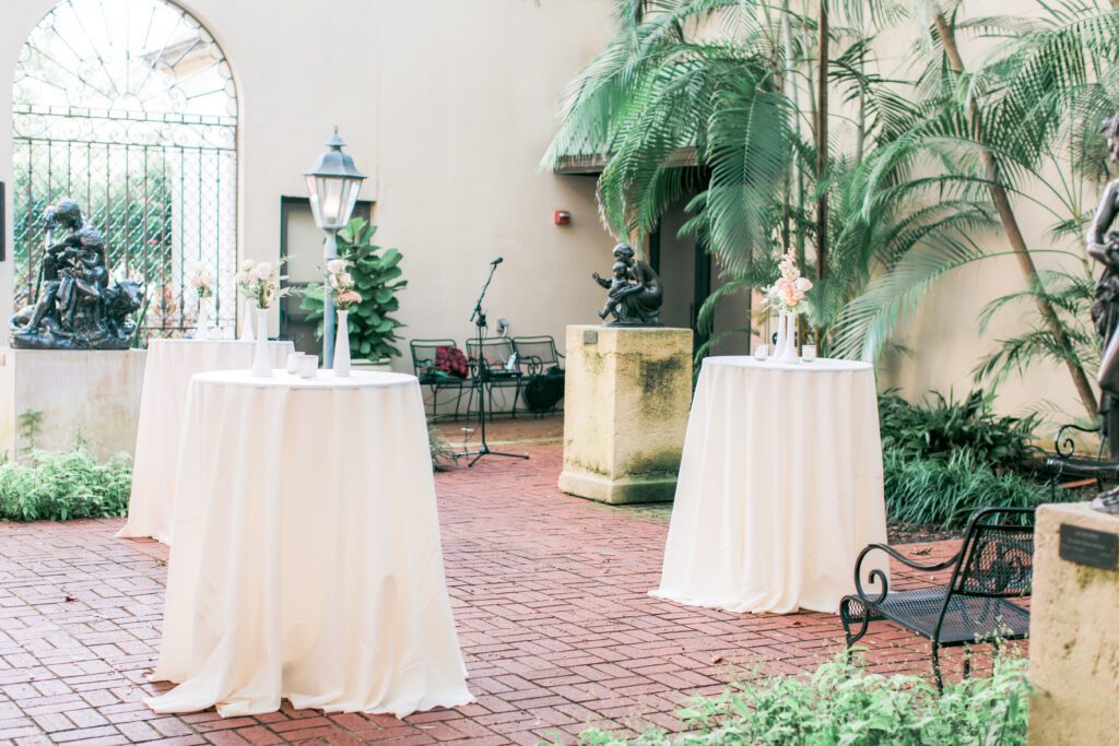 Outdoor reception setup in Museum of Fine Arts courtyard with cocktail tables and greenery