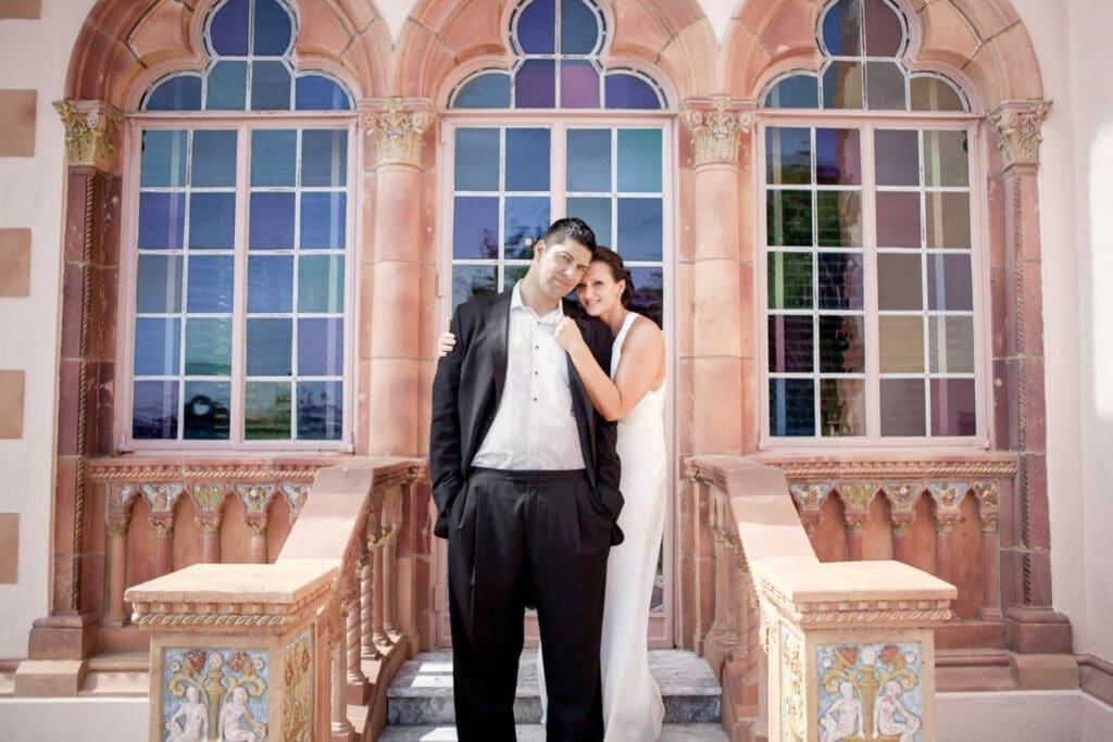 Bride and groom portrait in front of historic arched windows at The Ringling Museum courtyard in Sarasota