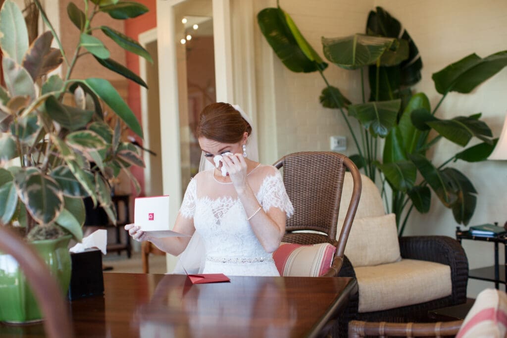 Bride standing near window in soft natural light before wedding ceremony