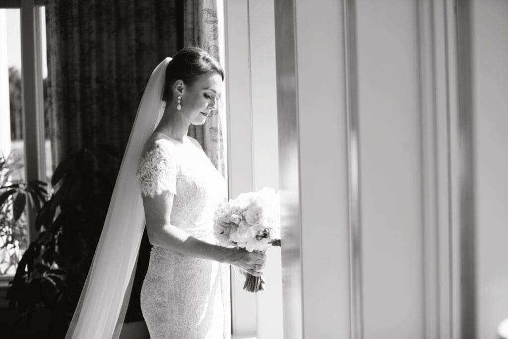 Black and white bridal portrait by window before Southern wedding ceremony