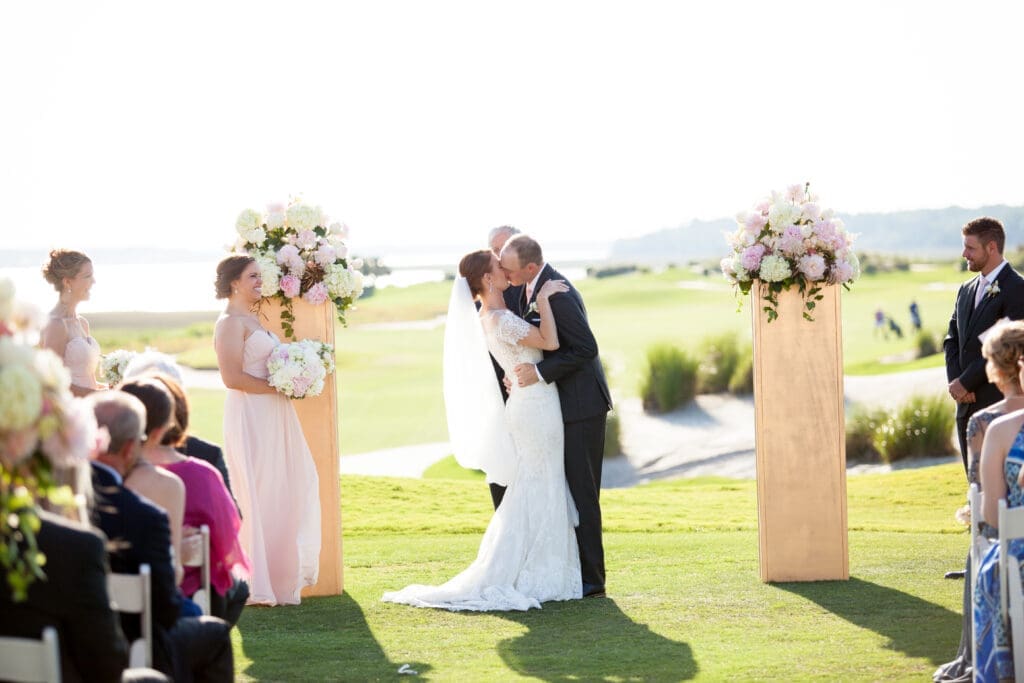Bride and groom smiling during outdoor wedding ceremony