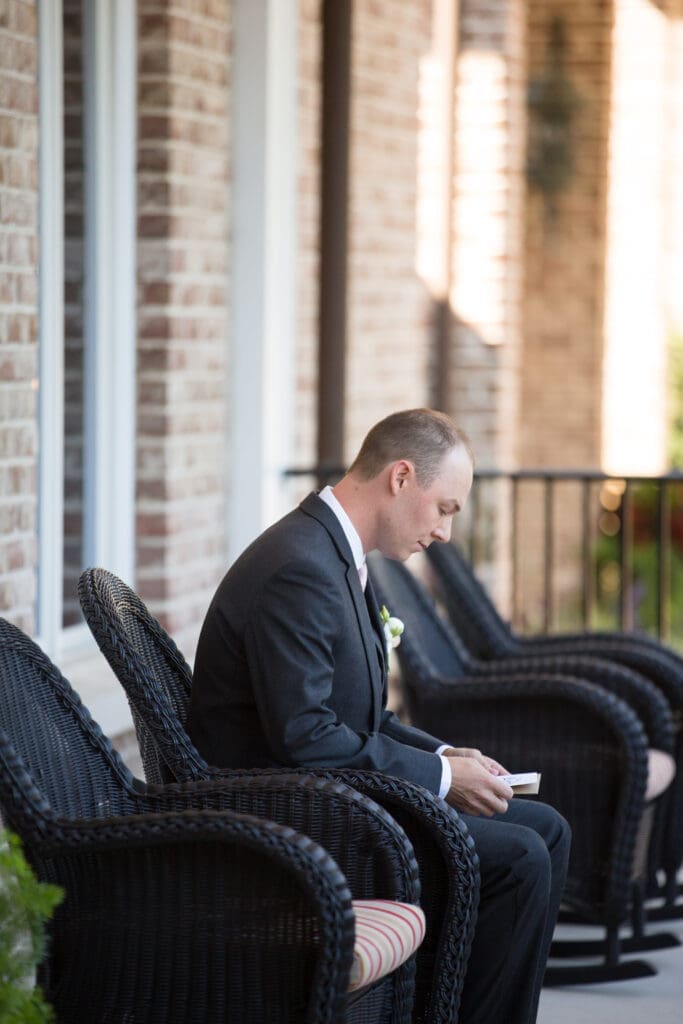 Groom sitting outside venue before ceremony at Colleton River Club