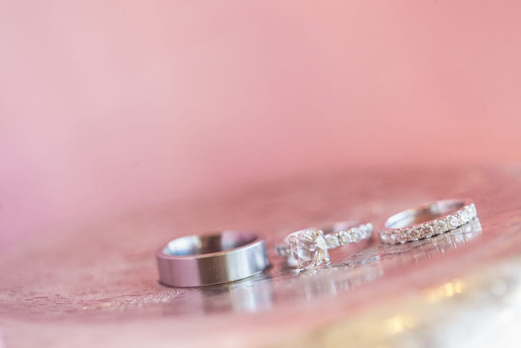 Wedding rings photographed on a pink surface during Hilton Head wedding day
