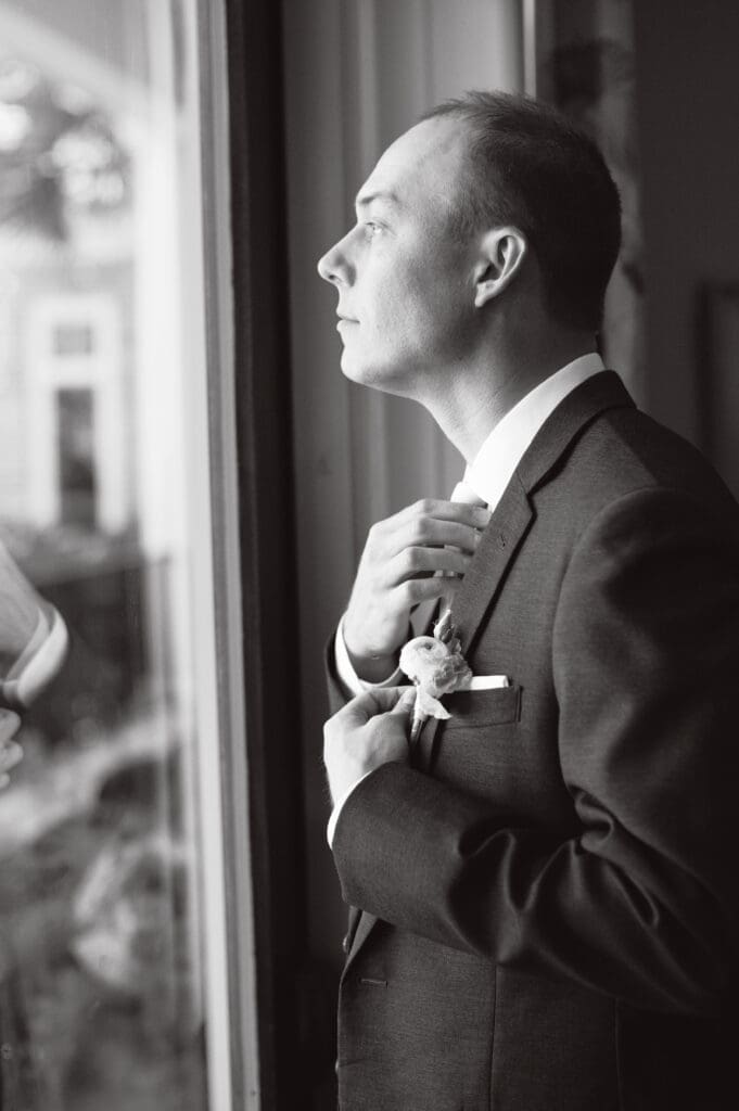 Black and white groom portrait adjusting tie before Hilton Head wedding