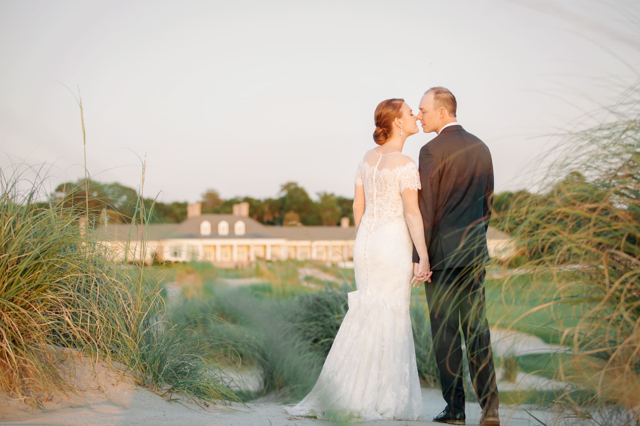 Bride and groom standing together in the dunes at a Hilton Head waterfront wedding venue